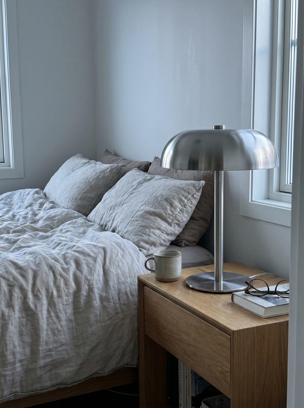 Brushed steel dome lamp on a bedside table with a book and glasses — Dalfa CH/FR