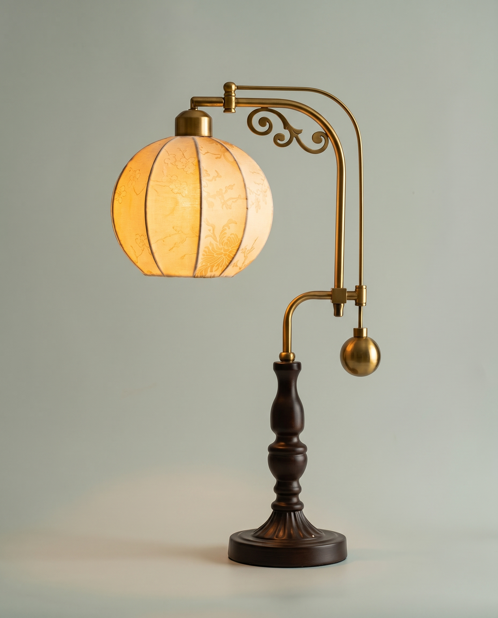Botanical Arm brass swing-arm lamp, botanical fabric globe, dark wood base, 58 cm — lit hero shot | Dalfa CH/FR