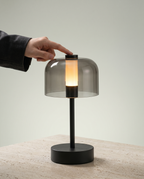Flame Bell smoked-glass bell lamp, LED flame 2000K, touch, USB-C cordless — in use, hand on touch control | Dalfa CH/FR