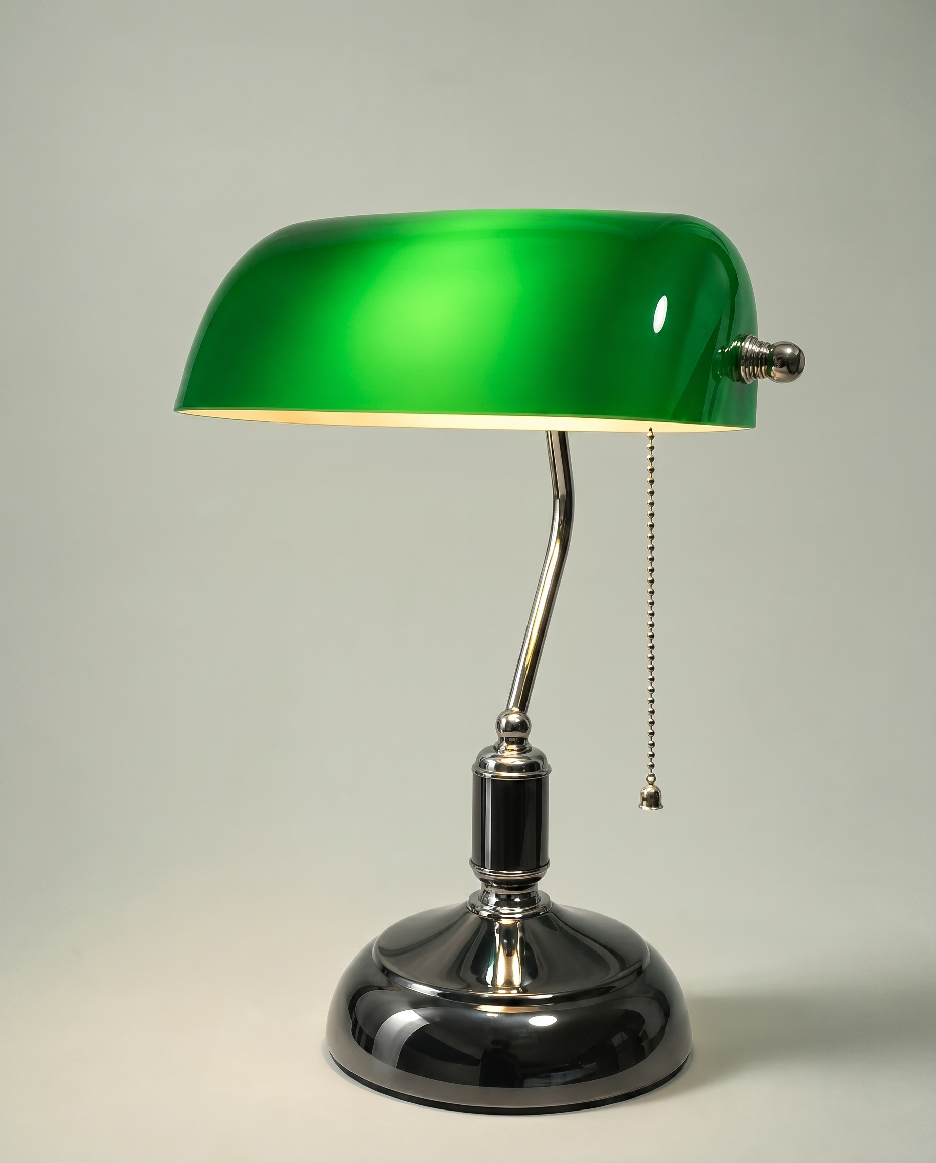 Green Banker desk lamp, emerald green glass shade, brass arm, dark chrome base — lit hero shot | Dalfa CH/FR