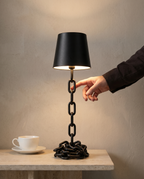 Chain Cone black iron chain lamp, conical shade, touch, USB-C cordless, 41 cm — in use, fingertip on the chain stem | Dalfa CH/FR