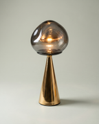 Mushroom Fumé smoked blown-glass globe lamp, golden cone base, dimmer 2700K — lit hero shot | Dalfa CH/FR