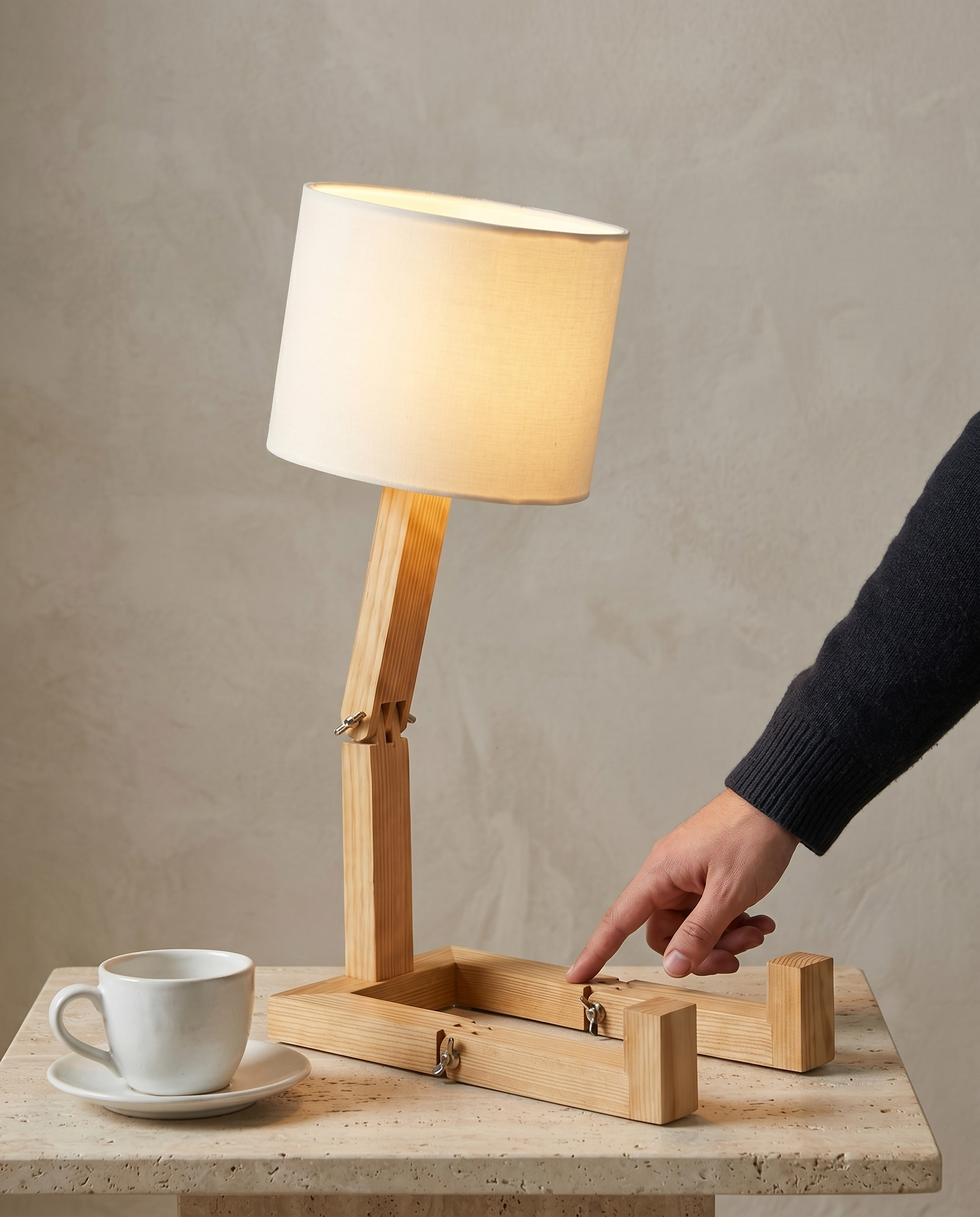 Wooden Step solid pine desk lamp, stepped base, cream drum shade, 47 cm — in use, fingertip on a lower bolted joint | Dalfa CH/FR