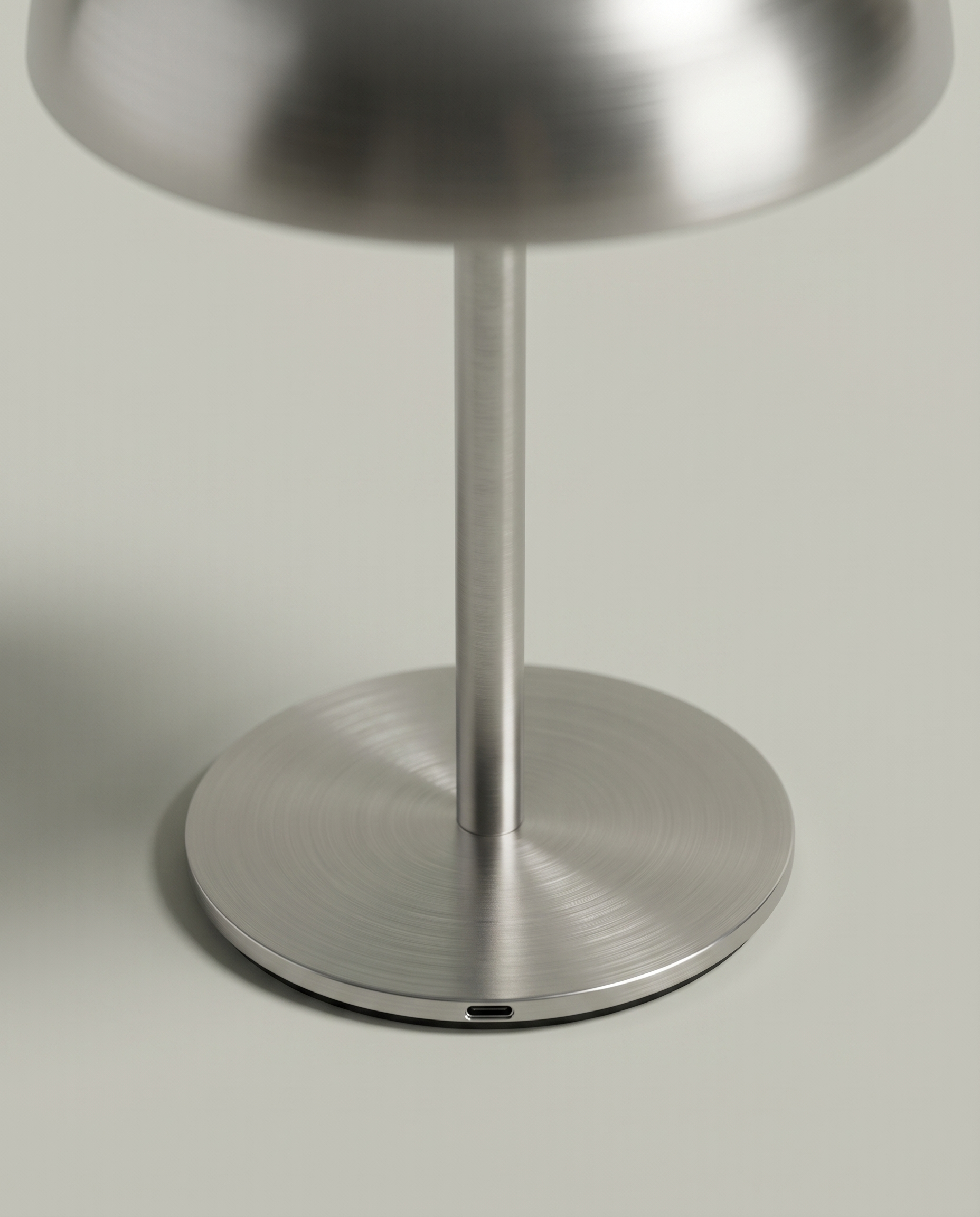 Close-up of the brushed steel base and USB-C charging port — detail | Dalfa CH/FR