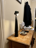 Matte black figure lamp lit on a hallway console with keys and a coat, real home — Dalfa CH/FR